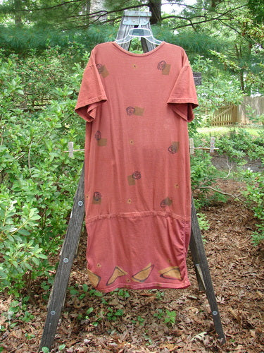 1990 B Base Dress Abstract Indian Sun Altered OSFA on a wooden rack, featuring a unique rounded hemline, ruching on sides, short sleeves, and a vintage Blue Fish signature patch.
