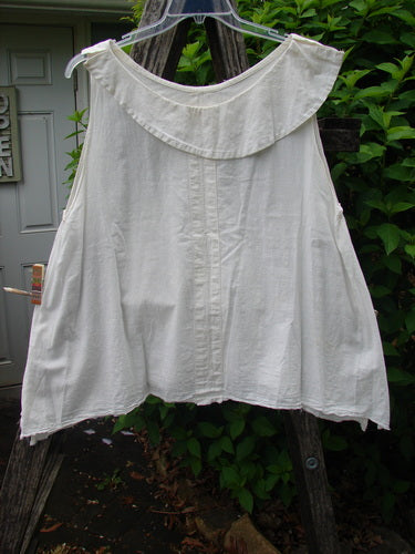 Magnolia Pearl Cotton Voile Sweet Collar Top White OSFA hangs outdoors, showcasing a full angular collar, ruffled yoke, and cross-stitched vertical band, embodying Bluefishfinder's vintage aesthetic.