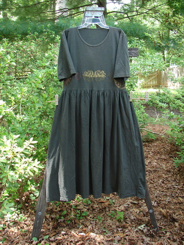 1992 Short Sleeved Simple Dress Metallic Black Sand Altered Size 1 displayed on a clothesline, featuring a semi-dropped waistline, full draping lower, and deeper rounded neckline with signature Blue Fish patch.
