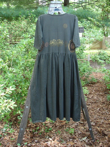 1992 Short Sleeved Simple Dress Metallic Black Sand Altered Size 1 on a rack, featuring semi-dropped waistline, full draping lower, wide neckline, Blue Fish patch, and metallic paint accents.