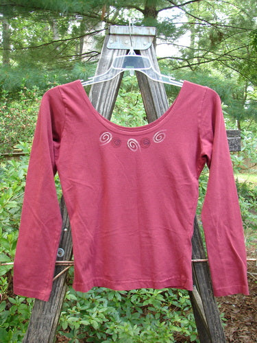 1995 Cotton Lycra Ballina Long Sleeved Layering Top Necklace Hollyberry Size 2 on an outdoor swinger, showcasing its fitted shape, ballerina neckline, and substantial stretch fabric.