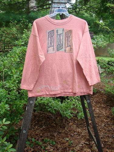 1995 Long Sleeved Tee Vintage Column Papaya Size 1 displayed on a wooden hanger outdoors, showcasing its thicker ribbed neckline, drop shoulders, and superior vintage column theme paint.