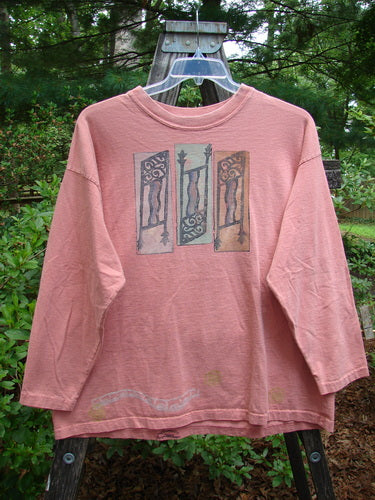 Alt text: 1995 Long Sleeved Tee Vintage Column Papaya Size 1 displayed on a wooden swing, showcasing its ribbed neckline and painted details.