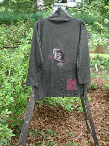 A 1994 Long Sleeved Vented Turtleneck Top in Edo Black, featuring an Asian fan theme and signature Blue Fish patch, displayed on a rack.