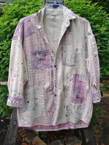 Magnolia Pearl Flannel Patched Surfside Shirt Sun Bleached OSFA, featuring a plaid patchwork style with paint splatters, button-up design, long sleeves, and distressed details, hanging outdoors.