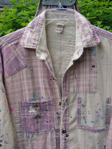 Magnolia Pearl Flannel Patched Surfside Shirt Sun Bleached OSFA, featuring hand distressing, generous patching, and paint splatters, hangs outdoors, showcasing its rustic charm and unique, artistic detailing.