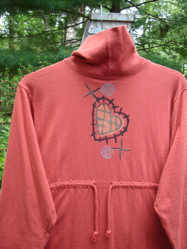 1995 Omega Dress Heart Fish Red Glaze Altered Size 1: A red sweatshirt with a heart and cross painted on it, featuring a heavy ribbed turtleneck, drop shoulders, and a drawcord backline.
