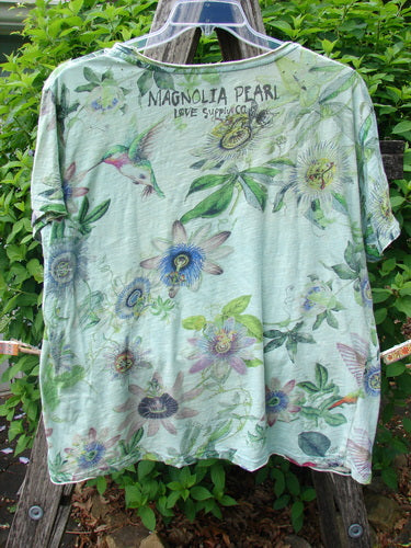 Magnolia Pearl Cotton Jersey Boyfriend Tee Passion Flower Big Sky OSFA displayed outdoors, showcasing its botanical print of vines, flowers, and hummingbirds, with visible MAGNOLIA PEARL LOVE SUPPLY CO. text near the neckline.