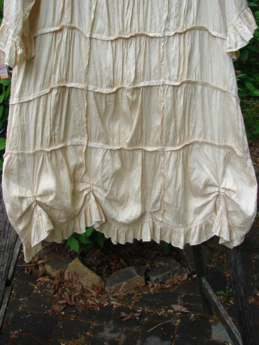 Magnolia Pearl Silk Cotton Drapery Dress Butter Creme OSFA features a tiered, bubble-style skirt with horizontal ruffled seams, fluttery hem ruffles, and an oval neckline, embodying vintage elegance.