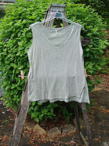 Magnolia Pearl Cotton Jersey Vented Layer Tank Top Green River OSFA displayed on a wooden ladder, showcasing its wider neckline, deep arm openings, raw flutter edges, vented sides, and unique hemline.