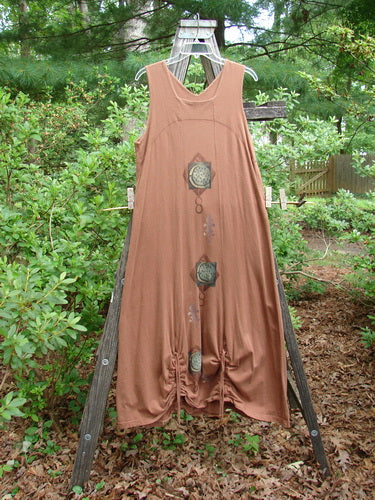 1998 Arcadia Jumper Harvest Moon Rockwood Altered Size 1, hanging on a clothes rack, featuring a double-paneled squared-off upper bodice, downward yoked empire waist seam, and full-length panels with vertical hem drawcords.