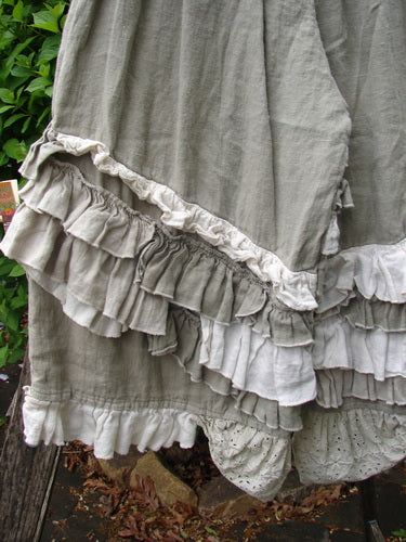 Magnolia Pearl Linen Eiffel Tower Bloomer Flaxen OSFA features tiered, ruffled layers in muted tones, showcasing a smocked waistline and signature patch, embodying Bluefishfinder.com's vintage, expressive style.