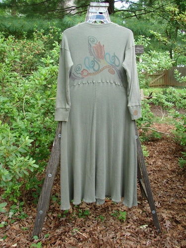 1995 Thermal Soliloquy Dress Abstract Greenwear Altered Size 2 displayed on a wooden stand, showcasing long sleeves, ribbed accents, and a sweeping hemline with intricate front snaps and architectural theme paint.