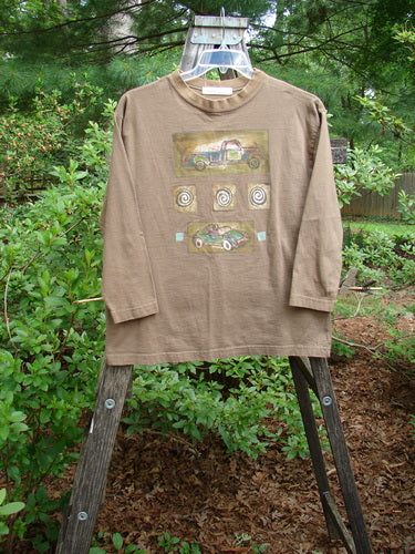 1996 Long Sleeved Tee featuring vintage truck and race car prints, displayed on a swing.