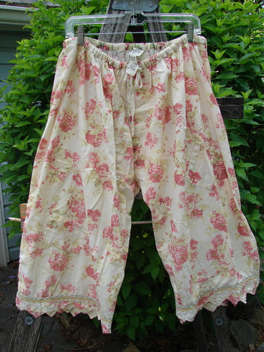 Magnolia Pearl Patched Khloe Bloomer, hanging outdoors, features a pink floral print on cream cotton with drawstring waist, scallop tape hems, and hand-mended rose patches, embodying Bluefishfinder.com’s vintage style.