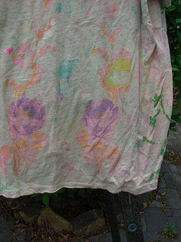 Magnolia Pearl Cotton Jersey Boyfriend Tee draped outdoors, showcasing its delicate watercolor-style floral motifs in soft hues, featuring a unique triangular wrap seam and shoulder distressing, capturing a bohemian, artistic essence.