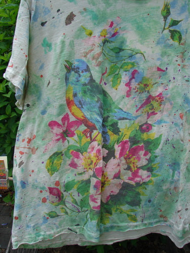 Magnolia Pearl Cotton Jersey Boyfriend Tee Songbird Floral OSFA features a colorful songbird and floral watercolor design on a light T-shirt, showcasing a relaxed fit with distressed shoulder details.