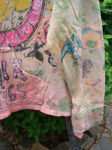 Magnolia Pearl Fleece Lucky Anna Glitter Sweatshirt Marais OSFA draped on a post, showcasing whimsical vintage-style prints with a blue songbird, botanical illustrations, and a distinctive 765 pocket.