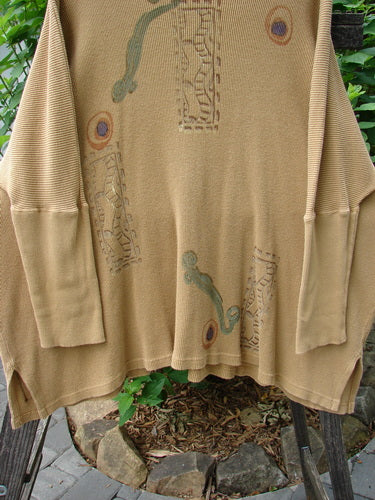 1995 Thermal Studio Pullover Tunic Abstract Road Burnished Gold OSFA on a clothes rack, showcasing abstract road-themed design, ribbed lower sleeves, and vented sides, capturing a cozy, relaxed drape.