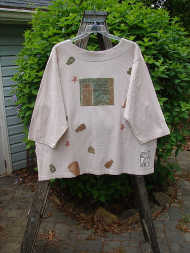 1993 Resort PJ Top Diner Treat Tea Dye Size 2 draped on a ladder; features muted forest-themed graphics, oversized fit, and wider shoulders, embodying Bluefishfinder.com's vintage creativity and individuality.