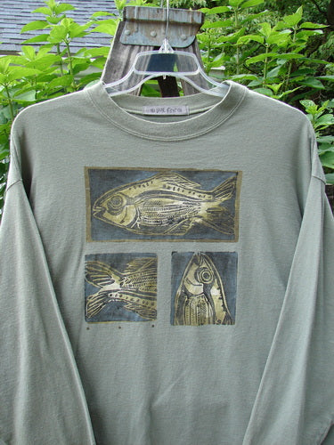 1996 Long Sleeved Tee Triple Fish Cricket Size 2, featuring detailed fish artwork on the front, drop shoulders, and a thicker ribbed neckline, made from medium weight organic cotton.