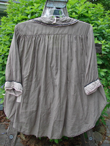 Magnolia Pearl Silk Cotton Poet's Billow Blouse Blue Grey Shore OSFA, draped over a ladder, features a ruffled collar, three-quarter sleeves, and a gathered back yoke in a delicate dot pattern.