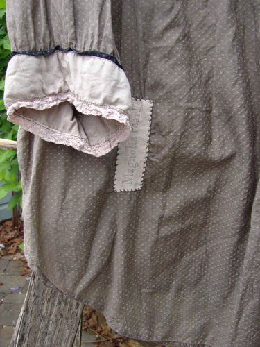 The Magnolia Pearl Silk Cotton Poet's Billow Blouse in Blue Grey Shore OSFA features a lightweight fabric with tiny white polka dots, accented with lace-trimmed cuffs and a fabric patch on the front.