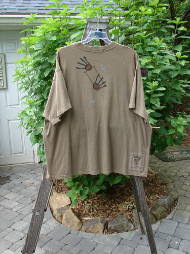 1995 Short Sleeved Tee Snail Garden Bramble Size 2 hanging on a swinger, featuring a ribbed neckline, drop shoulders, and a super snail garden theme design on mid-weight cotton.