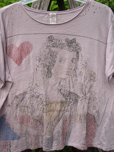 Magnolia Pearl Cotton Jersey Boyfriend Tee Queen of Hearts Pink Dust OSFA: Light mauve tee with a distressed look, featuring a crowned woman with roses and a red heart, hanging outdoors.