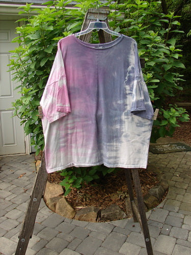 Barclay Oversized Center Seam Tunic Top Unpainted Mottled Pastels OSFA displayed on a wooden clothes rack, showcasing its wide, boxy shape with significant drop shoulders and a ribbed neckline.