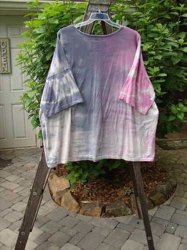 Barclay Oversized Center Seam Tunic Top Unpainted Mottled Pastels OSFA displayed on a wooden ladder, showcasing its wide, boxy shape and significant drop shoulders with a center seam.