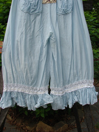 Magnolia Pearl Silk Voile Window Lace Ruffle Pocket Bloomer Sky OSFA, featuring lace and ruffled hems, elastic waist, and patch pockets, hangs outdoors, embodying vintage charm and creative freedom.