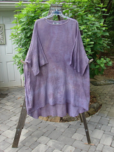 Barclay Gauze Ana Tunic Dress Unpainted Mottled Lavender Rain OSFA displayed on a clothes hanger, showcasing its wide three-quarter sleeves, seamless shoulder, and varying hemline.