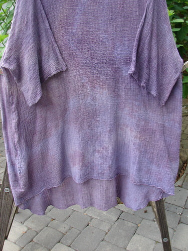 Barclay Gauze Ana Tunic Dress in Mottled Lavender displayed on a rack, showcasing its wide three-quarter sleeves and seamless shoulders.