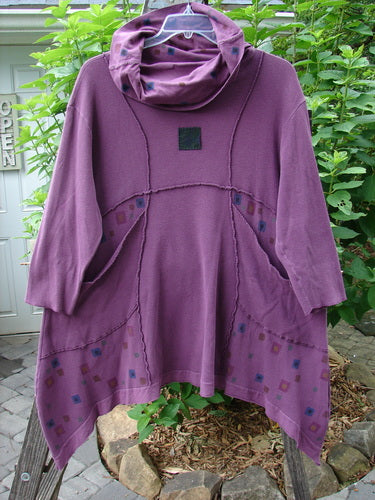 Barclay Patched Thermal Cowl Turtleneck Tunic in Dusty Red Plum displayed on a pole, showing its floppy cowl neck, curved stitchery, oversized pockets, and sectional panels.