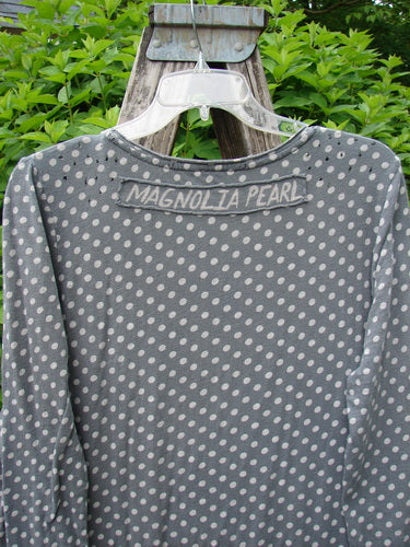 Magnolia Pearl Cotton Dylan Dress Ozzy Tiny Continuous Polka OSFA hanging outdoors on a clear hanger, showcasing its polka-dot pattern, rolled neckline, tighter lower sleeves, and distinctive distressed seams.