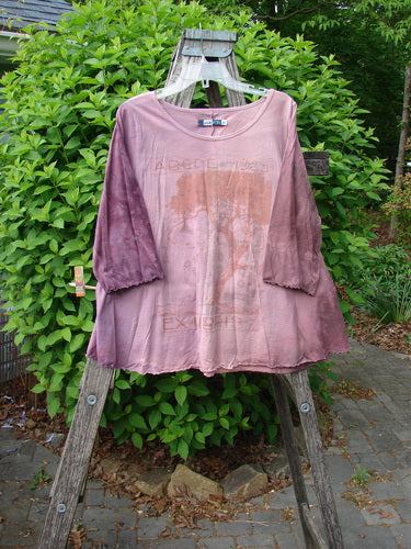 Barclay Three Quarter Sleeved Cafe Tee Alphabet Mottled Peony Size 0, features a flowing A-line silhouette with curly edgings, displayed on a wooden drying rack amidst a garden setting.
