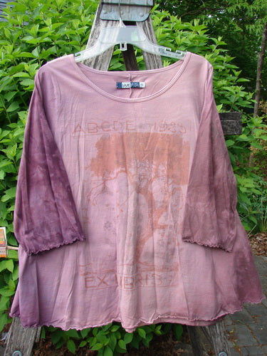 Barclay Three Quarter Sleeved Cafe Tee Alphabet Mottled Peony Size 0, featuring a dusty mauve tie-dye, boat-neck and screen-printed tree design, hangs on a ladder, showcasing crinkle texture and lettuce-edge hems.