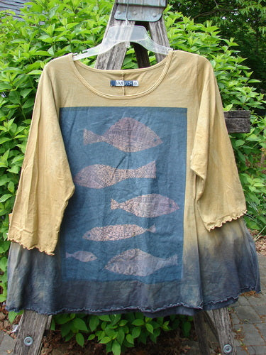 Barclay Three Quarter Sleeved Cafe Tee Sea of Fish Mottled Mustard Size 0, featuring a sea-themed graphic with fish silhouettes, hangs on a ladder, highlighting its unique artistic design and organic cotton material.