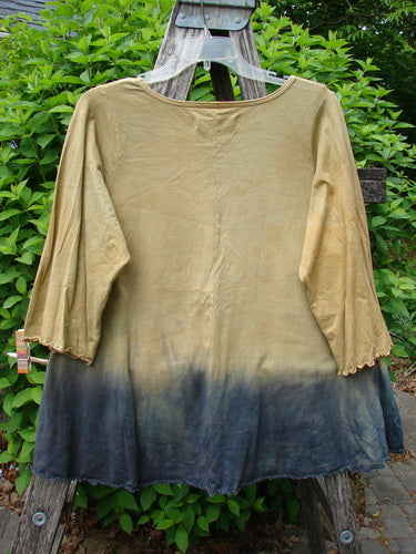 Barclay Three Quarter Sleeved Cafe Tee, Sea of Fish Mottled Mustard Size 0, displayed on a garden ladder. Features an ombré effect, round neckline, and curly edgings, highlighting its unique A-line shape.
