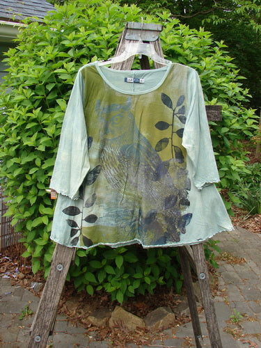 Barclay Three Quarter Sleeved Cafe Tee Owl Forest Mottled Mint Size 0 hangs on a rustic ladder, showcasing its leaf-patterned design, A-line shape, and unique curly edge details.