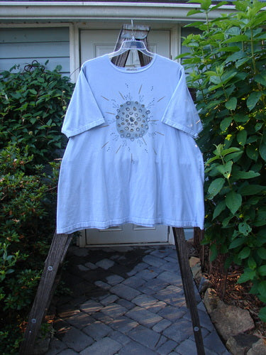 Barclay Short Sleeved A Line Tee Circle Pebble Sky Size 2 displayed on a hanger, showcasing its wide boat neckline, short sleeves, and circular pebble design on organic cotton fabric.