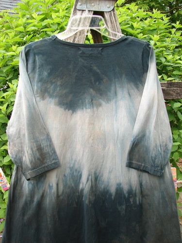 Barclay Wander Tunic Tee Rain Star Mottled Night Size 0, long-sleeved with a dip-dye effect, hangs on a garden ladder, showcasing its unique A-line flair and varying lengths.