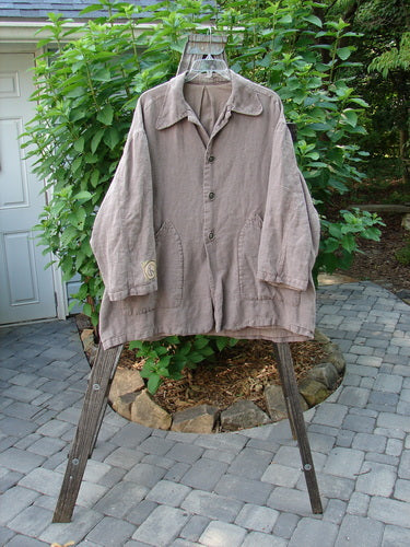 Alt text: 1999 PMU Single Patch Hemp Yard Coat in Shale, displayed on a hanger, showcasing its heavy-weight cotton hemp fabric, thick metal buttons, and painted pockets.
