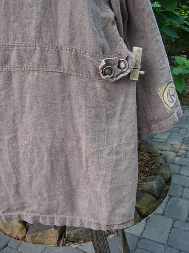 Close-up of the 1999 PMU Single Patch Hemp Yard Coat Shale Size 2, showcasing thick metal buttons, triangular front pockets, and adjustable side tabs, highlighting its textured hemp cotton fabric and perfect condition.