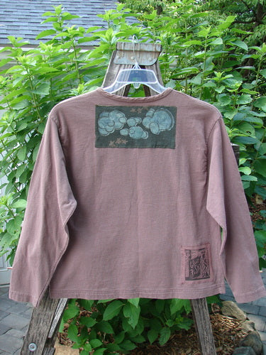 1994 PMU Patched Long Sleeved Tee Rosewood Size 1 displayed on a hanger, featuring a slightly shortened hemline, long sleeves, and unique playground and cloud-themed patches.