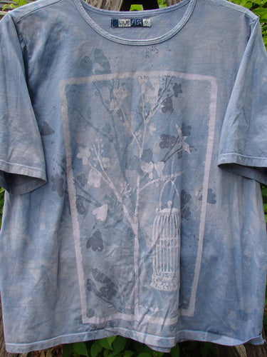 Barclay Fiona Crop Straight Tee Victorian Mottled Bluestone Size 0 features a Victorian garden theme with a tree silhouette and birdcage graphic, soft distressed look, and wide sleeves, hanging outdoors.