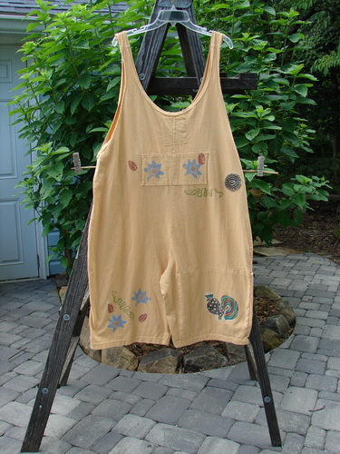 1991 PMU Farmer Brown Overall Pant Jumper Rear Rooster Goldenrod OSFA displayed on a wooden stand, featuring painted pockets, circle patches, and drop bushel front pockets, highlighting its vintage farm theme.
