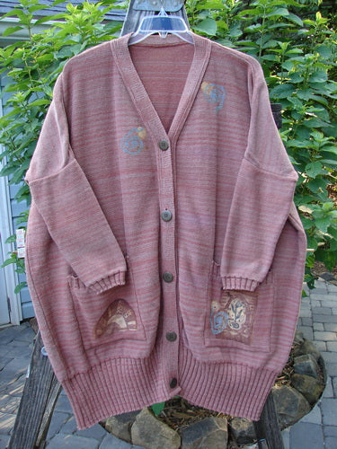 1995 Fireside Cardigan Sweater Single Sprig Marled Brick OSFA: Pink sweater with deep neckline, metal buttons, drop shoulders, flared hips, and ribbed oversized pockets, showcasing intricate bird design.