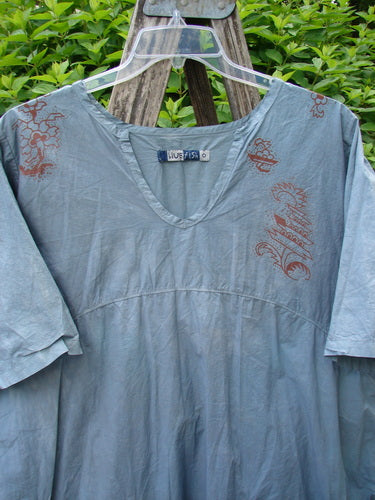 Barclay Percale Key Pocket Hi Low Dress features a pale blue-grey tunic with rust-colored prints on shoulders, V-neck, elbow-length sleeves, embodying Bluefishfinder.com's vintage charm and creative individuality.